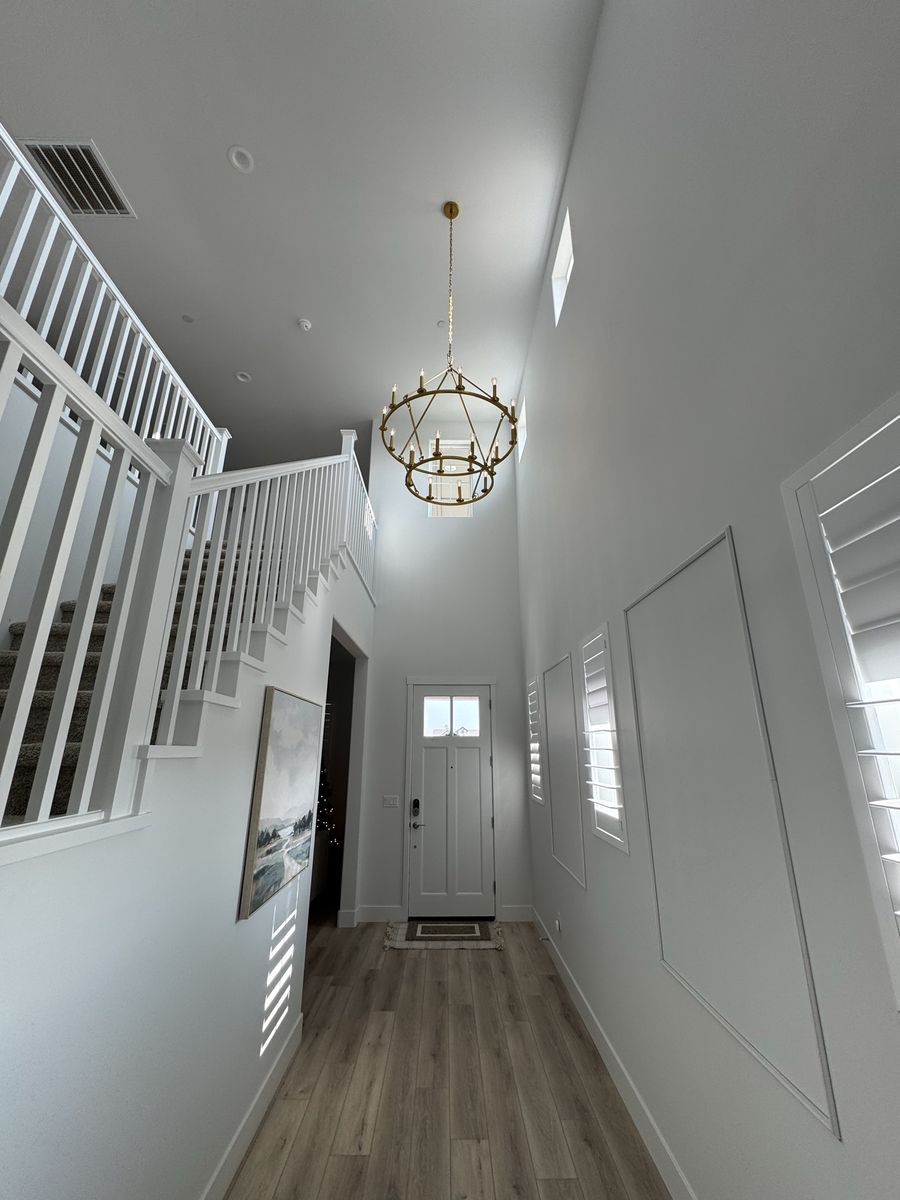 Gold candle-style chandelier in a two-story entryway